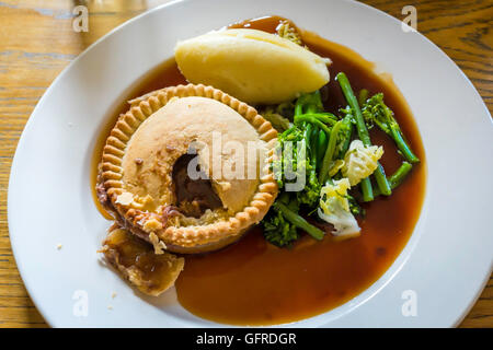 Gustoso pasto di mezzogiorno e la bistecca ale pie con mostarda purè di patate e broccoli sugo di cipolla Foto Stock