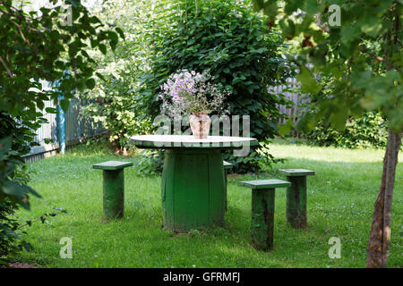 Vaso di fiori su un tavolo in giardino Foto Stock
