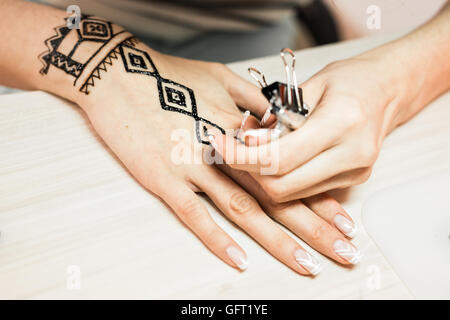 Giovane donna artista mehendi pittura henna sulla mano Foto Stock