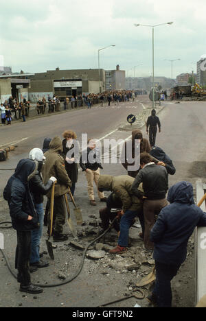 Sommosse rivolte giovani che scavano lungo la strada ( Shankill Road ) per fare missili da lanciare contro l'esercito britannico. Belfast Irlanda del Nord Regno Unito 1980s 1981 HOMER SYKES Foto Stock