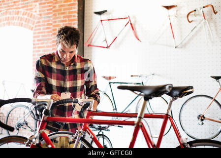 Un uomo in un ciclo di lettura di negozio l'etichetta del prezzo su una bici Foto Stock