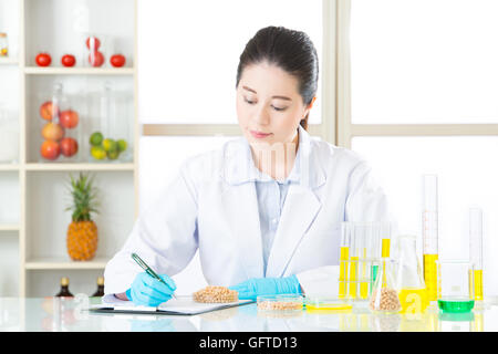 Asian donna scienziato la registrazione dei Suoi dati è importante per la modificazione genetica Foto Stock