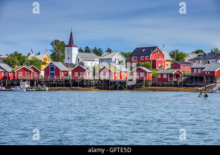 Red Rorbu, Reine, Isole Lofoten con il bianco chiesa di legno, Artico, Norvegia, Scandinavia, Europa Foto Stock