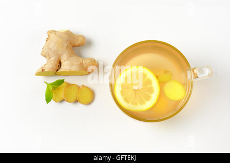 Tazza di tè allo zenzero con limone e zenzero fresco su sfondo bianco Foto Stock