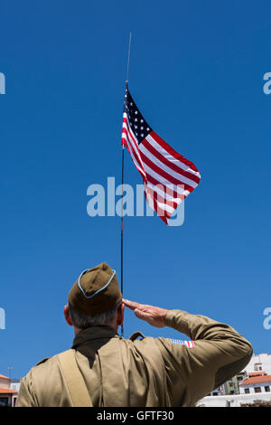 L uomo nella seconda guerra mondiale noi uniforme militare saluta la bandiera americana Foto Stock