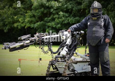 Kineton EOD (l'eliminazione degli ordigni esplosivi) operatore vestito con una tuta di bomba con una bomba-robot di smaltimento. Foto Stock