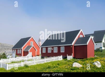 Tradizionale in rosso groenlandese case con giardini recintati in estate. Porto coloniale (Kolonihavnen), Nuuk, Groenlandia Foto Stock