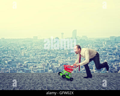 Uomo con carrello giocattolo e background urbano Foto Stock
