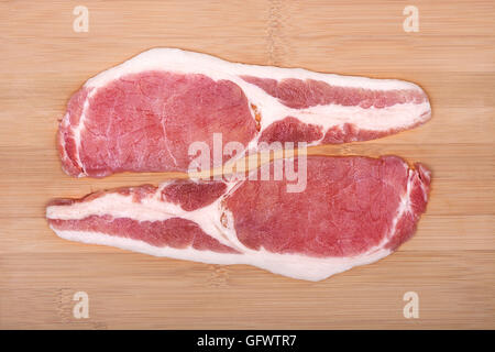 Materie fette di pancetta su un tagliere di legno. Da sopra. Foto Stock