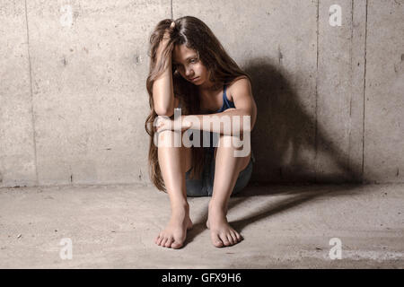 Triste e solitaria ragazza accanto a parete Foto Stock