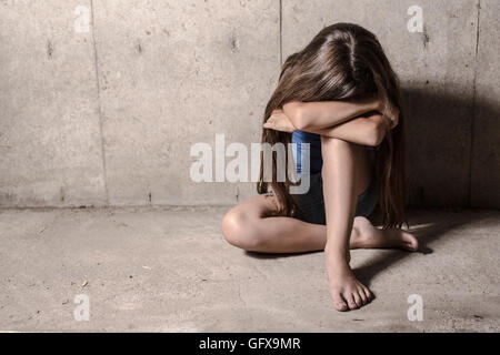 Triste e solitaria ragazza accanto a parete Foto Stock