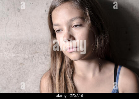 Triste e solitaria ragazza accanto a parete Foto Stock