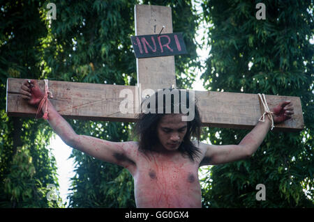 Cristiani indonesiani prendere parte alla rievocazione storica di Gesù Cristo Crocifissione in Santa Maria Regina del Rosario chiesa. La processione Foto Stock