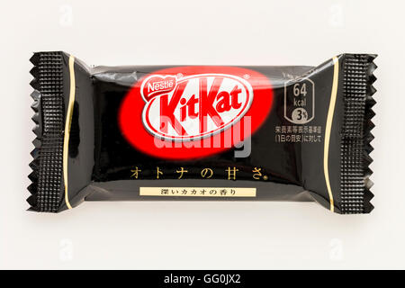 Kitkat giapponese. Confezionate singolarmente barra di cioccolato, cioccolato fondente favore. Involucro nero. Sfondo semplice. Foto Stock