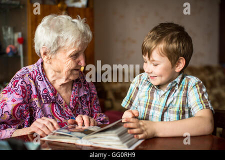Nonna mostra album fotografico al piccolo nipote. Foto Stock