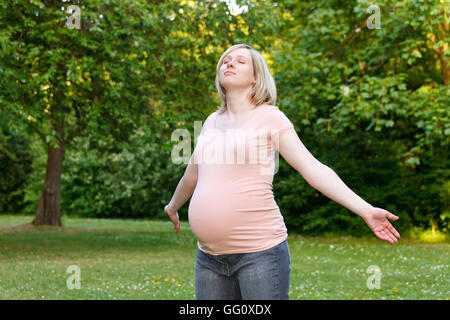 Donna incinta nel parco Foto Stock