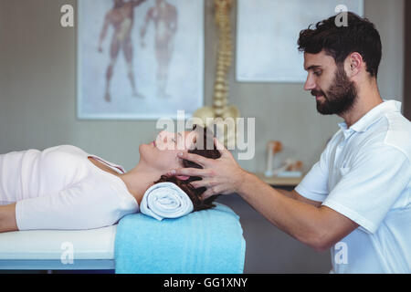 Fisioterapista dando massaggio della testa di una donna Foto Stock