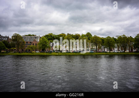 Guardando ad est attraverso il Fiume Ness a Inverness, a nord della Scozia. Il fiume è in piena alluvione dopo un periodo di forte pioggia e il cielo è burrascoso. Foto Stock