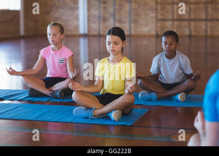 La scuola di meditazione per bambini durante la lezione di yoga Foto Stock