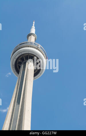 CN Tower Toronto contro un cielo blu con i minuscoli puntini rossi di persone di completare il bordo a piedi Foto Stock