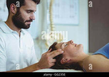 Fisioterapista dando massaggio della testa di una donna Foto Stock