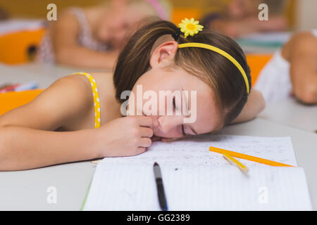 Schoolgirl dormire a scrivania Foto Stock