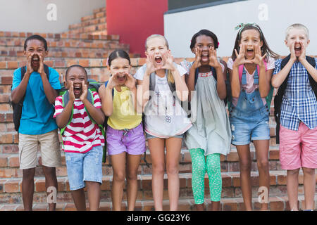 Gruppo di ragazzi gridando e urlando a scuola la scala Foto Stock