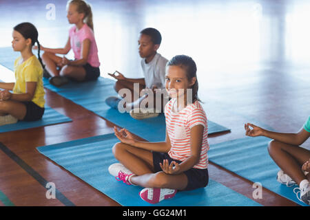 La scuola di meditazione per bambini durante la lezione di yoga Foto Stock