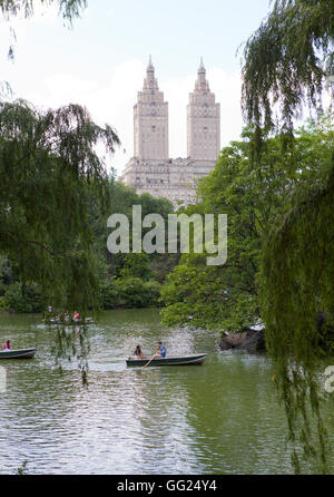 Persone imbarcazioni a remi in una calda giornata d'estate vicino alla Loeb Boathouse nel Central Park. Foto Stock