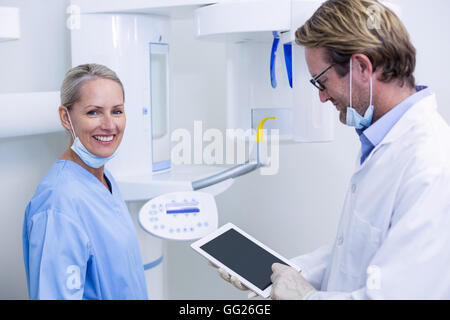 Dentista e assistente lavorando su tavoletta digitale Foto Stock