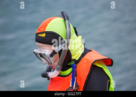 Scuba Diver in colorato fluorescente in attesa di marcia per andare in mare a Swanage in luglio Foto Stock