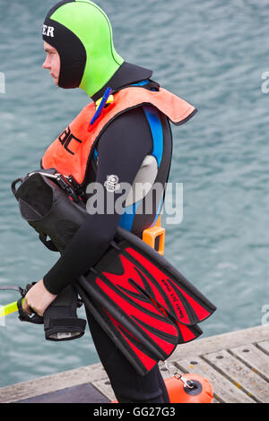 Scuba Diver in colorato fluorescente in attesa di marcia per andare in mare a Swanage in luglio Foto Stock