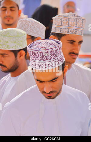 Omani uomini tradizionalmente condita frequentando il mercato di capra a Nizwa, Western Hajar, Oman Foto Stock