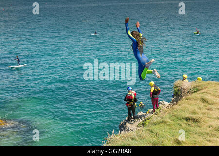 Un giovane adolescente tombstoning off scogliere in Newquay, Cornwall. Foto Stock