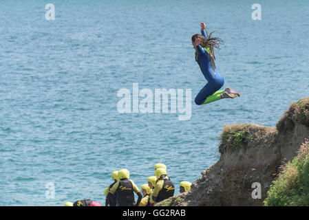 Un giovane adolescente tombstoning off scogliere in Newquay, Cornwall. Foto Stock