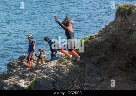 Un giovane adolescente tombstoning off scogliere in Newquay, Cornwall. Foto Stock