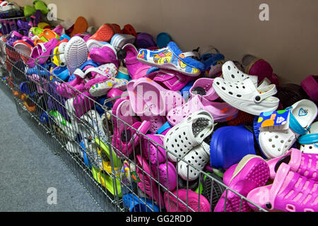 Pila di flip flop e sandali in negozio. Mucchio di pantofole in offerta a buon mercato Negozio. Foto Stock