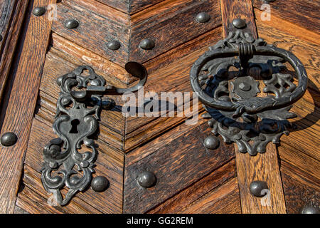 Vecchia maniglia in metallo con respingente su una porta di legno Foto Stock