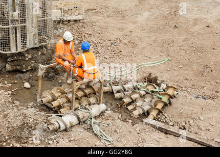 Lavoratori edili seduto accanto a un mucchio di macchina di foratura su un lato ferroviaria sito. di Ilkeston, nel Derbyshire, Inghilterra. il 1° au Foto Stock