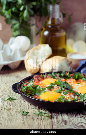 Uovo fatta in casa il piatto con la salsa di pomodoro servita in ghisa pan, shakshouka, comfort food Foto Stock