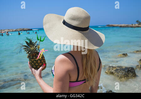 Donna di mano azienda esotici cocktail di ananas Foto Stock