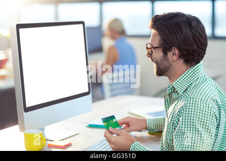 Graphic Designer facendo shopping online Foto Stock