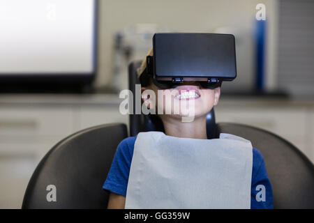 Boy utilizzando la realtà virtuale cuffia durante una visita dentistica Foto Stock