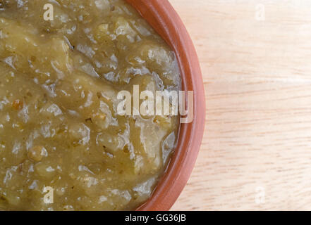 Top vista ravvicinata di una ciotola di culantro salsa di cottura su una tavola di legno. Foto Stock