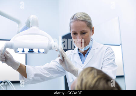 Dentista femmina regolazione luce dentale Foto Stock