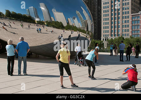 Le persone che posano per una foto di fronte al Cloud Gate (il bean) in Millennium Park, Chicago, Illinois marathon weekend. Foto Stock