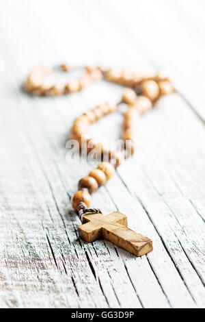 Il rosario in legno talloni sul vecchio tavolo. Foto Stock