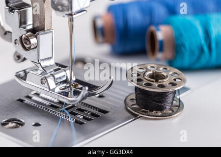 Meccanismo della macchina per cucire con ago e filo rocchetti sui thread di  background Foto stock - Alamy