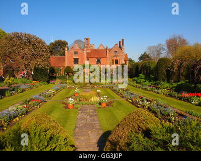 Chenies Manor House sunken garden con molla tulip frontiere, melo, stagno ornamentale, rivolta a sud ovest con il blu del cielo. Foto Stock