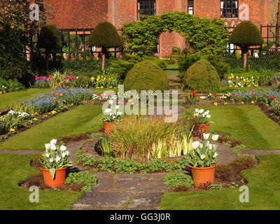Chenies Manor House tulip frontiere, sunken giardino e prato a sud ovest dell'edificio;pentole intorno al laghetto ornamentale Foto Stock